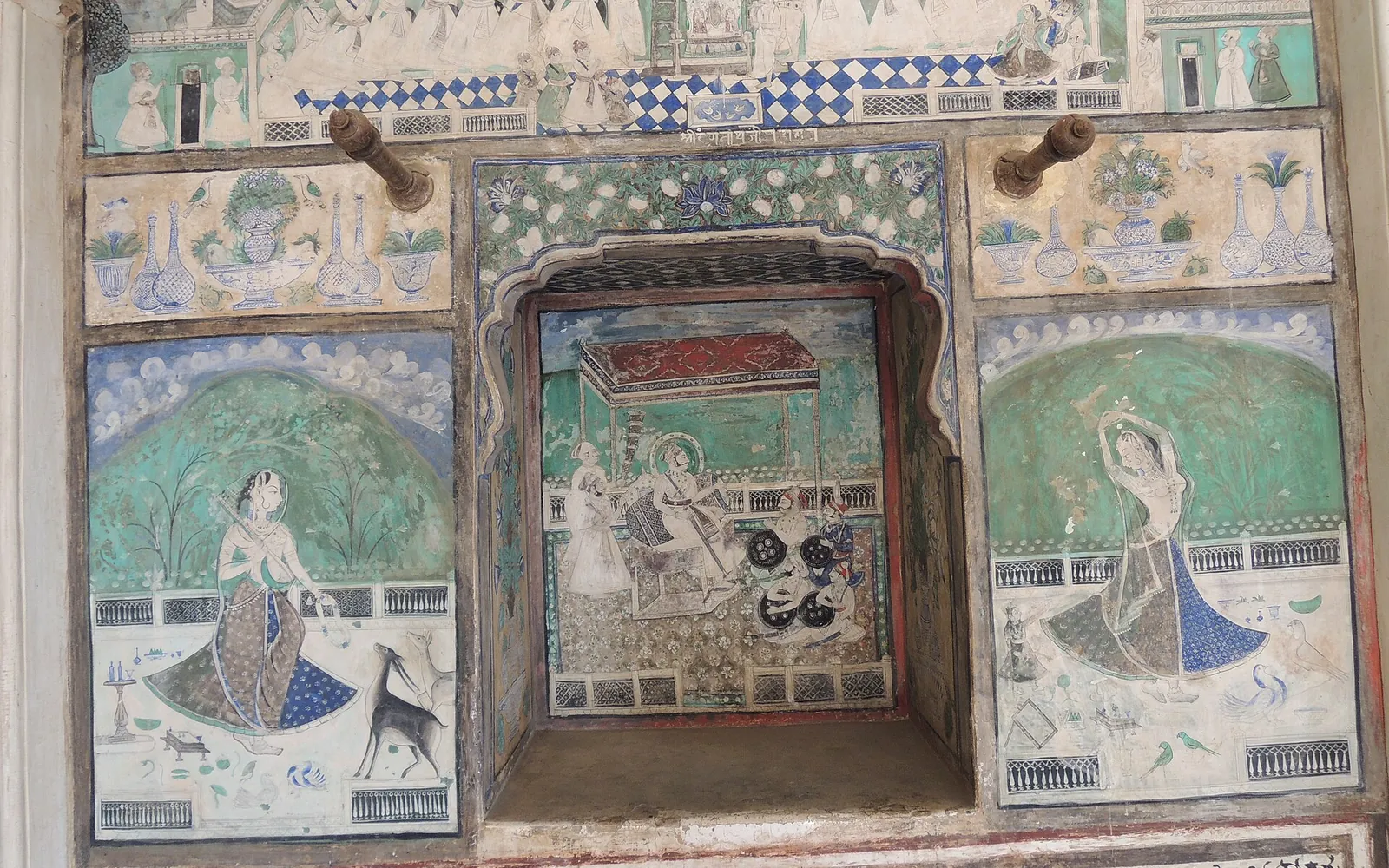 Wall paintings of court ladies, a ruler on a throne and blue-and-white borders in the Chitrashala of Bundi's Garh Palace