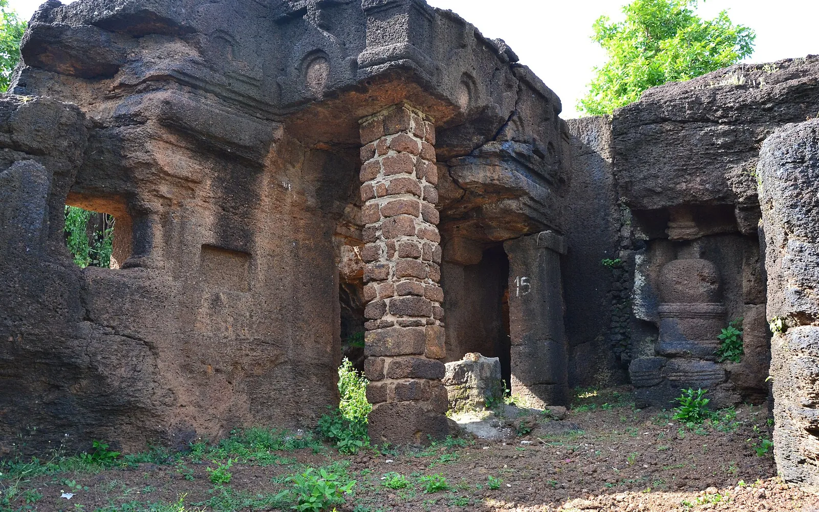 Weathered laterite rock-cut cave and pillar at the Kolvi Buddhist caves in Jhalawar district