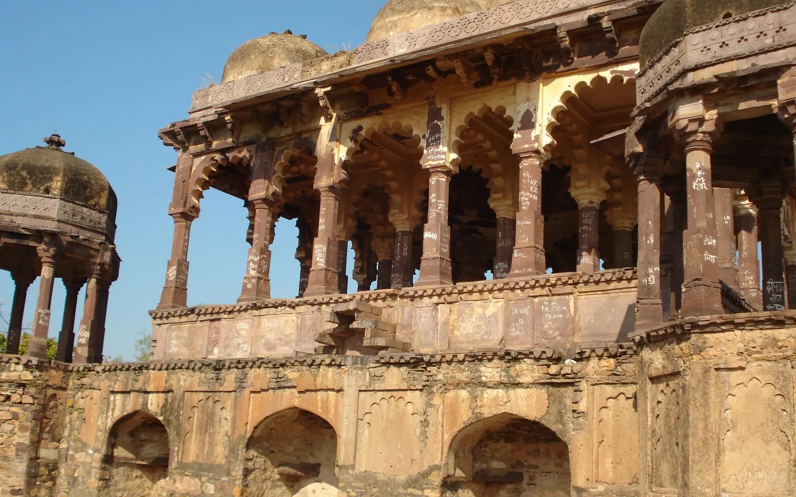 Domed pavilions and arches of Ranthambore Fort against a blue sky
